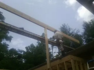 Carpenter setting a ridge beam over a new addition frame — Ice Dam Removal by Roofing Brothers in Sperryville