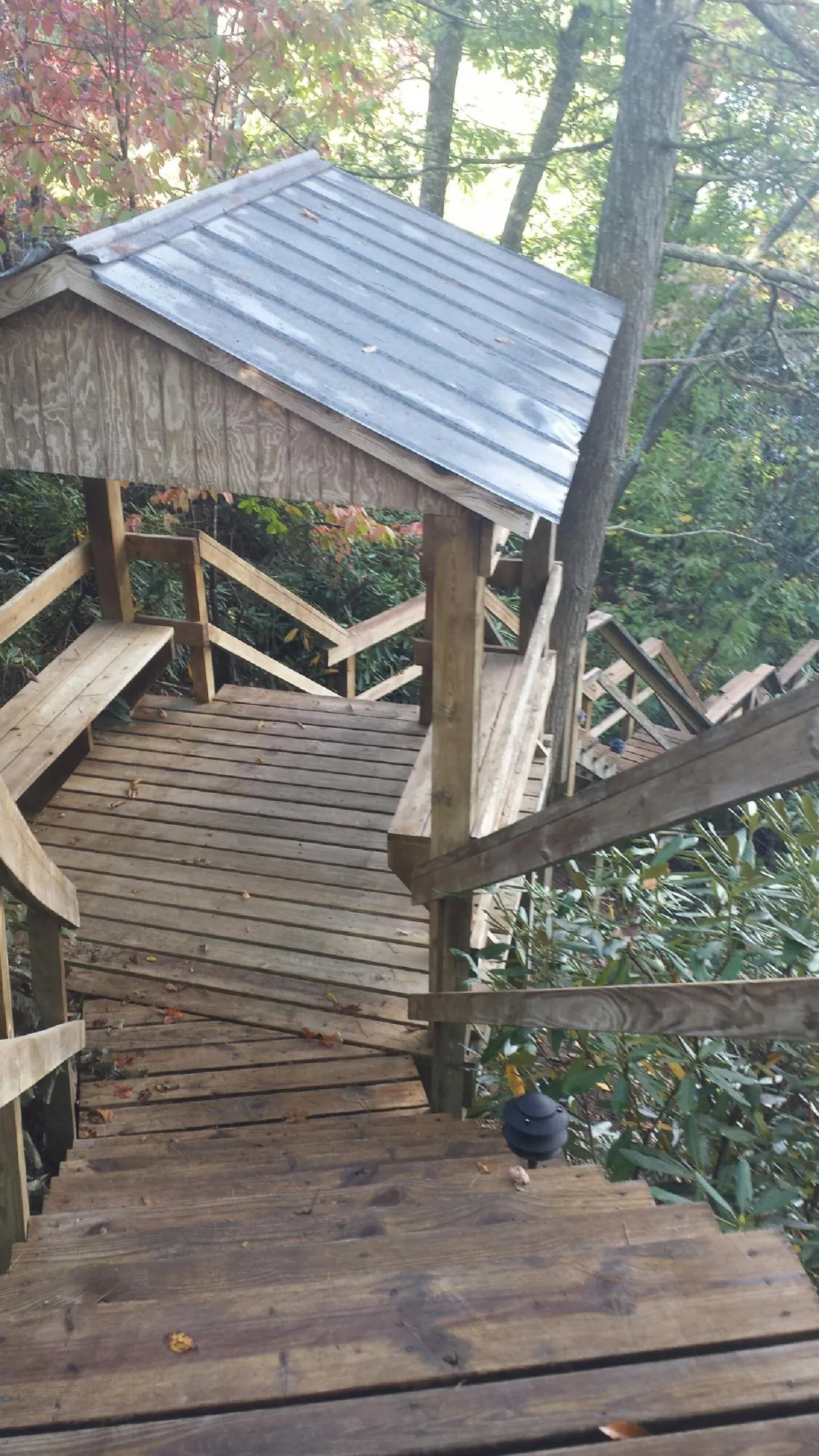 Metal roofed shelter over wooden steps on a wooded walkway — Skylight Repair & Installation work by our crew in Sperryville